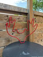 Full view of red Antlers coat rack on table