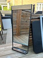 Full view of metal wall mirror with shelf