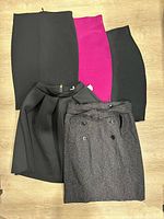 Five skirts laid flat showing colors and styles