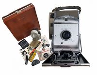 Group shot: camera, leather case, accessories, manuals