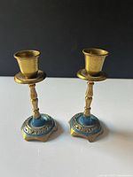 Full view of both brass candlesticks standing upright