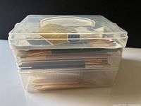 Closed clear plastic three-tier case filled with brushes