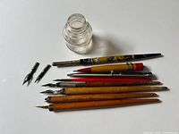 Overall view showing inkwell, seven writing instruments and two loose nibs