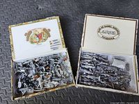 Two open cigar boxes showing large quantity of unpainted lead soldier castings