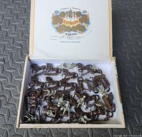 Open cigar box showing numerous painted horses and a few riders