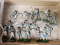 Box containing 16 painted lead French infantry soldiers on bubble wrap