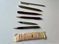 All six pens/pencils and Pentel refill displayed