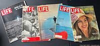 All five LIFE magazines fanned out on black surface