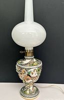 Full view of lamp showing ceramic base, brass collar, glass globe and chimney