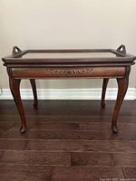 Front view of table with tray in place, showing legs and apron carving