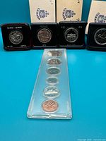 Front view showing three clamshell dollar coins and mint set