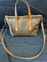 Front view of Fossil patterned handbag with strap attached
