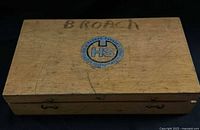 Closed wooden case with HS logo and BROACH marking