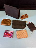 Seven assorted pouches and coin purses arranged on surface
