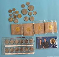 Overall view of all coins including loose group, four Coca-Cola coins in flips, Millennium set, Royal Wedding coin
