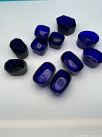 Group of all 11 cobalt blue glass salts assorted shapes