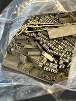 Close view of assorted metal letterpress blocks in plastic bag