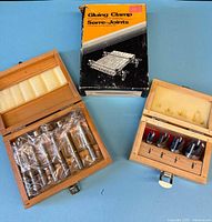Overall view showing two wooden cases and boxed gluing clamp