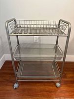 Front view of three-tier metal rolling cart on casters