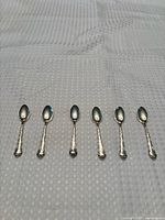 Six Birks Regency Pattern teaspoons lined side by side