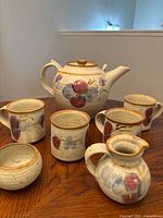 Full set showing teapot, 4 mugs, creamer and sugar bowl