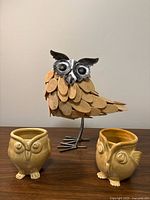 Owl figurine with two ceramic owl mugs on tabletop