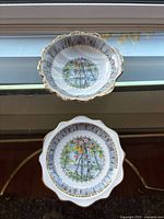 Both shell-shaped bowls front view showing pattern and gilt rims