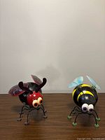 Both insect ornaments side by side on tabletop