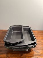 Stack showing two loaf pans on top of rectangular pan and glass dish below