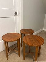 Three round wooden folding tray tables front view