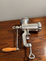 Side view of meat grinder showing clamp, crank and hopper