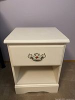 Front view of off-white wood nightstand showing drawer and open shelf