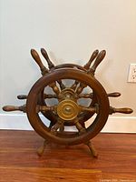Front view of double wooden ship’s wheel helm on stand