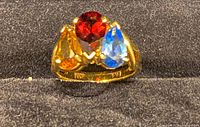 Front view of ring showing red, blue, yellow stones and gold setting
