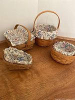 Four Longaberger baskets with liners and protectors displayed together
