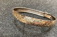 Full view of bracelet showing two-tone floral design