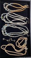 Tray view of four necklaces, bracelet and earrings showing overall contents