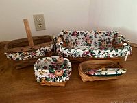 All four Longaberger baskets with liners, protectors and one lid displayed together