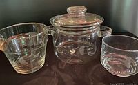 Three clear glass Princess House pieces: covered pot, flared planter, small bowl