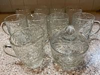 Group shot of eight mugs, creamer, sugar bowl with lid