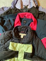 Stack of five women’s coats showing colors and collars