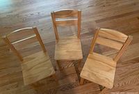 Top view of three wooden children’s chairs upright