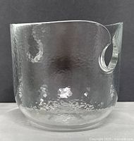 Front view of hand-hammered clear glass bowl showing wave-shaped lip and cut-out accent.