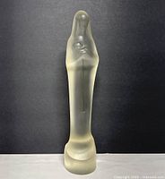 Front view of the tall frosted glass Madonna and Child sculpture against a dark background.