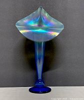 Front view of the tall iridescent blue art glass vase showing the wide flared top and round base.