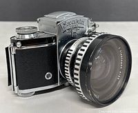 Angled front view showing prism, body, and mounted lens