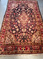 Top-down photo showing full rug with visible floral and geometric pattern and border.
