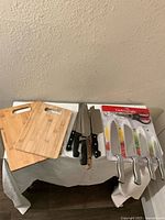 Overview of all items including knives with black handles, 5-piece Cooking Light knives with color-coded blades and stainless steel handles, and two bamboo cutting boards.
