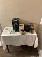 Full set overview showing incense burner, diffusers, candles, and glass holders on table covered with white cloth.