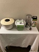 Full lot showing salad spinner, coffee dispenser, salt and pepper shakers, grater, and two additional containers.